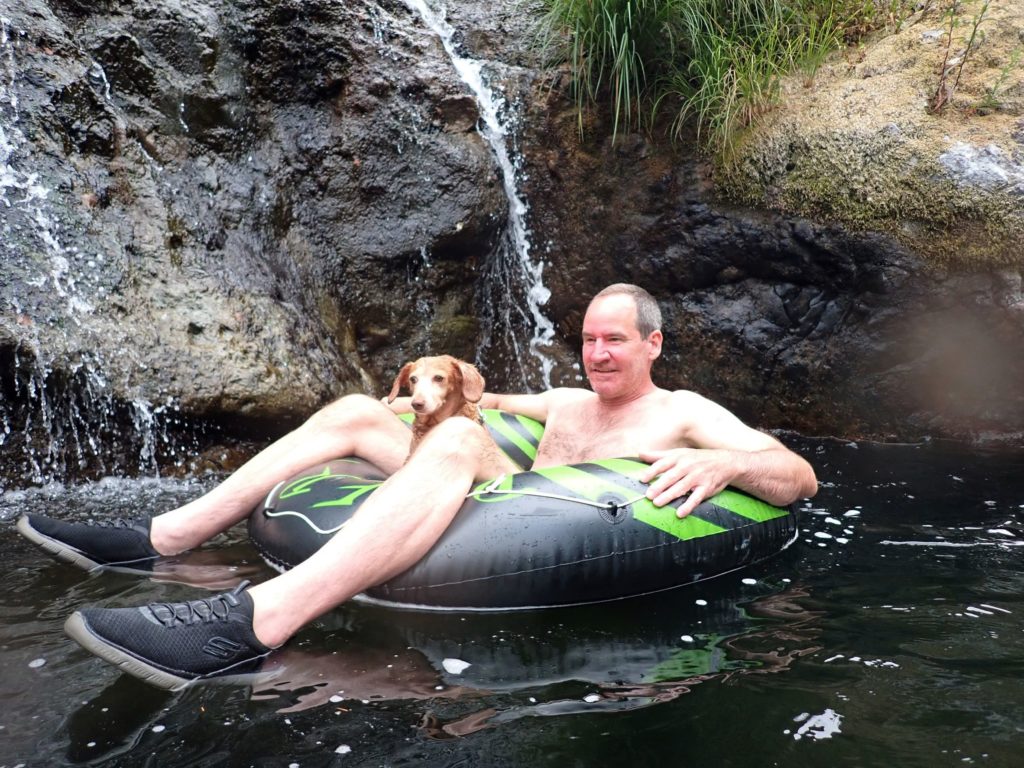 A man and a dog on an innertube at Dougan Falls